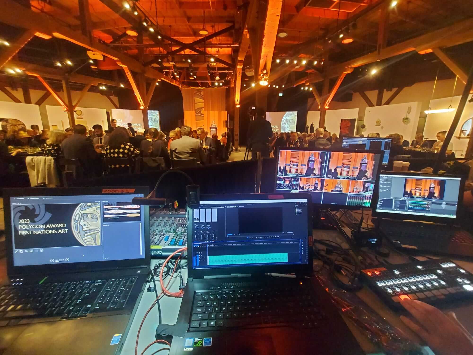  A room with multiple laptops and a large screen, set up for an AV mobile event with live streaming. Client: BCAF